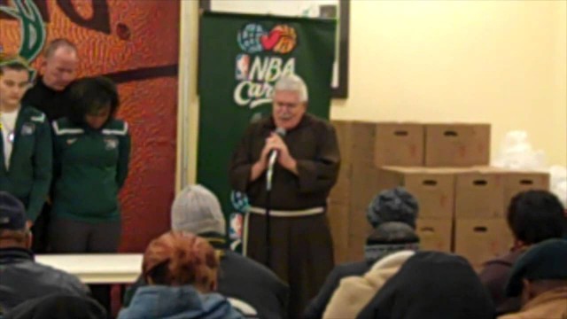 'Fr. Perry leads families in prayer before the Milwaukee Bucks\' Holiday Food Box distribution'