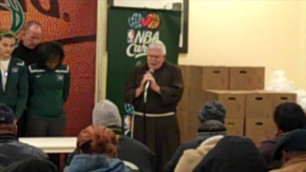 'Fr. Perry leads families in prayer before the Milwaukee Bucks\' Holiday Food Box distribution'